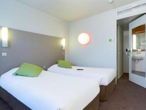 蓬图瓦兹钟楼塞吉庞托瓦斯酒店的带浴室的客房内设有两张单人床。