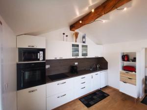 滨海圣芒德里耶Jolie Maison au coeur du village的厨房配有白色橱柜和黑微波炉