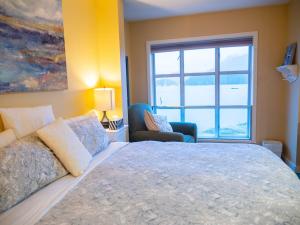 托菲诺Waterfront View of the Inlet, Short Walk to Town的一间卧室设有一张大床和一个窗户。