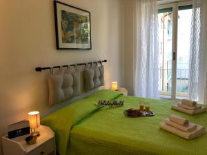 都灵Casa di Max by Holiday World的一间卧室配有绿床和2条毛巾