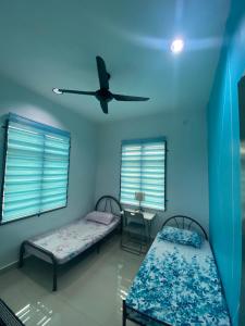 关丹Homestay Mak Abah的客房设有两张床和吊扇。