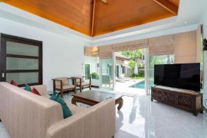 拉威海滩Balinese Style 3BR Villa Morning Forest, Nai Harn的客厅配有大屏幕平面电视