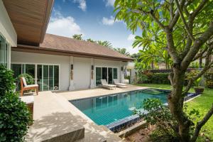 拉威海滩Balinese Style 3BR Villa Morning Forest, Nai Harn的一座房子后院的游泳池
