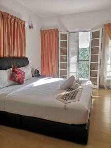 吉隆坡伍贰拾下安邦旅馆的窗户客房内的一张大白色床