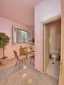 阿基欧斯尼古拉斯Ruby Apartment的一间带卫生间、桌子和椅子的浴室
