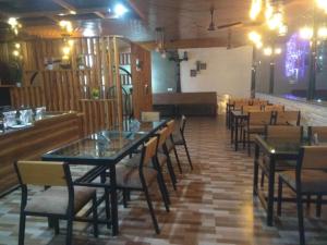 瑞诗凯诗Panambi Tapovan Resort的一间带桌椅的用餐室和一间酒吧