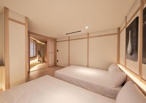 首尔UH Suite Central Seoul的一间卧室设有两张床和窗户。