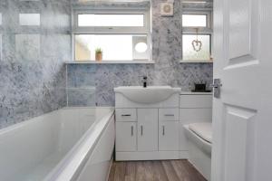 克利索普斯Cosy home by the sea的白色的浴室设有水槽和浴缸。
