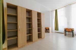 奥拉迪亚Collegium Varadinum的客房设有木制架子、桌子和窗户。