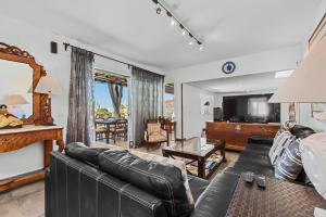 普拉亚布兰卡Villa Patos的客厅配有真皮沙发和电视