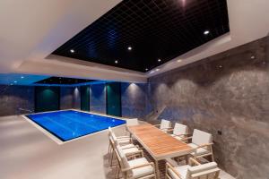 塔什干Hotel Marwa Tashkent Pool&Spa的游泳池位于带桌椅的房间
