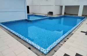 话毛生Homestay Studio Apartment Bentara Suite, Kompleks Mutiara Gua Musang的大楼内一个蓝色的大型游泳池