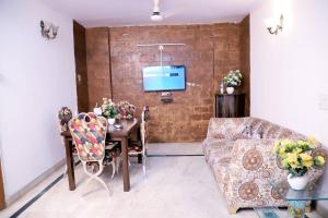 新德里Divine India Service Apartment,2Bhk, D-198,SAKET的带沙发、桌子和电视的客厅