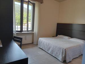 拉奎拉Hotel Porta Rivera Plesso Stazione的一间卧室设有一张床和一个大窗户