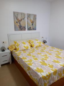 阿德拉Apartamento El Ingenio的一间卧室配有一张黄色和白色的被子。