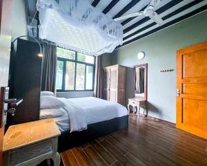 江比阿Aquamarina Hotel & Villas的一间卧室设有一张大床和一个窗户。