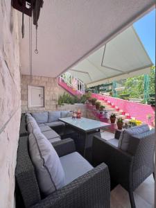 特罗吉尔Lilac Apartments的带沙发和桌椅的天井。