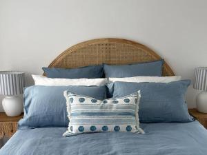 洛恩Seaview Treehouse - three minute walk to the beach的一张带蓝色和白色枕头的床