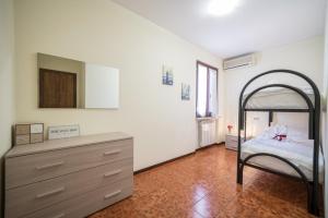 西尔米奥奈Gardappartamenti Sorgente Pool的一间卧室配有一张床和一个梳妆台