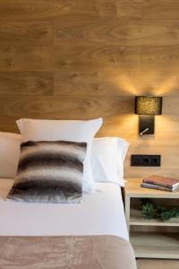 安道尔城阿克塔艺术酒店的一间卧室设有一张床和木墙
