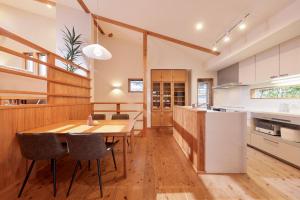 白滨Crystal Besso Shirahama的厨房以及带木桌和椅子的用餐室。