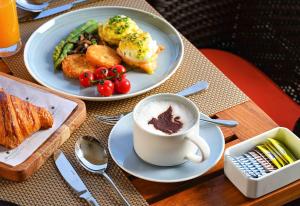 班加罗尔JW Marriott Hotel Bengaluru Prestige Golfshire Resort & Spa的餐桌,带两盘食物和一杯咖啡的桌子