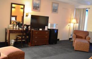 BluefieldEconomy Inn Bluefield的酒店客房配有书桌和电视,