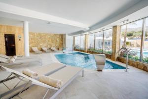 坎佩略Dormio Resort Costa Blanca Beach & Spa的游泳池,位于带椅子和窗户的房间