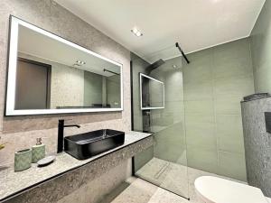 埃雷特里亚Oasis Luxury Apartments的一间带水槽和镜子的浴室
