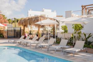 坎佩略Dormio Resort Costa Blanca Beach & Spa的游泳池旁的一排白色椅子和遮阳伞