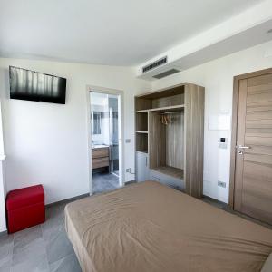 波利卡斯特罗巴森迪诺Resort Policastro的卧室配有一张床,墙上配有电视。