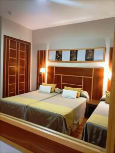 拉卡尔洛塔Hotel Carmen的一间卧室设有两张床和两个窗户。