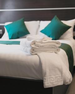 埃布韦尔Level Inn的一张带白色床单和绿色枕头的床