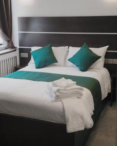 埃布韦尔Level Inn的一张带绿色枕头的床和毛巾