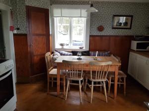 斯韦格Charmig gård med bastu, strandtomt och utedusch i naturskönt område的厨房配有木桌、椅子、桌子和桌子