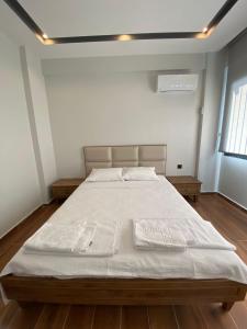 库萨达斯KARAASLAN GROUP TATİL EVLERİ的一间卧室配有一张带白色床单的大床