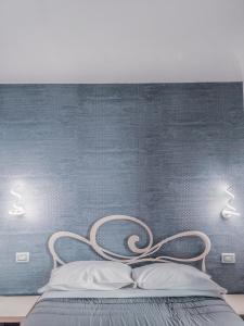 佛罗伦萨纳西拉旅馆的蓝色墙上一张带两个灯的床