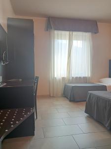 拉奎拉Hotel Porta Rivera Plesso Stazione的一间卧室设有两张床和窗户。