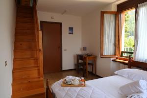 蓬泰迪莱尼奥Villa Luzzago的一间卧室设有一张床、楼梯和楼梯。