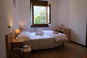 蓬泰迪莱尼奥Villa Luzzago的一间卧室设有一张大床和一个窗户。