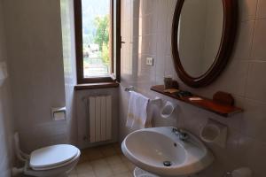 蓬泰迪莱尼奥Villa Luzzago的一间带水槽、卫生间和镜子的浴室