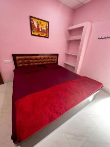 RāmtekHotel Tathastu的一间卧室配有一张带红色毯子的床