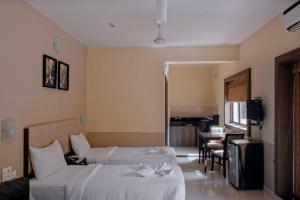 多纳保拉IKIGAI Green Valley Beach Resort的酒店客房设有两张床和一张桌子。