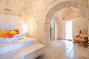 奇斯泰尼诺Trullo Suite in Masseria的一间卧室设有一张大床和一个拱门