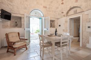 奇斯泰尼诺Trullo Suite in Masseria的一间配备有白色桌椅的用餐室