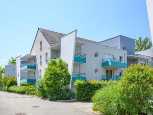 普雷斯科普Vacancéole - Ker Goh Lenn - Vannes / Morbihan的白色的公寓楼设有蓝色的阳台