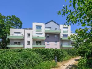普雷斯科普Vacancéole - Ker Goh Lenn - Vannes / Morbihan的公寓大楼前方有绿色灌木丛