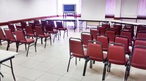 索罗卡巴国际广场酒店的一间教室,配有红色的桌椅和屏幕