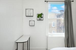 伦敦Spacious Serenity in the Heart of Central London的白色的客房设有书桌和窗户。