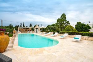 奇斯泰尼诺Trullo Suite in Masseria的一个带躺椅的游泳池